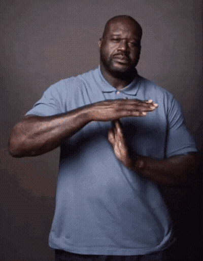 A Man In A Blue Shirt Holds His Hands Together In Front Of His Chest GIF