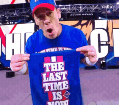 A Man In A Blue Shirt Holds Up A Shirt That Says The Last Time Is Now GIF