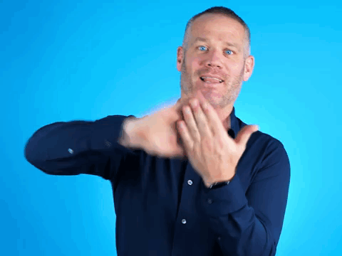 A Man In A Blue Shirt Is Clapping His Hands Against A Blue Background GIF