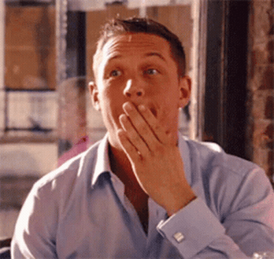 A Man In A Blue Shirt Is Covering His Mouth With His Hands GIF