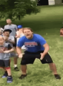 A Man In A Blue Shirt Is Dancing In A Park With Children GIF