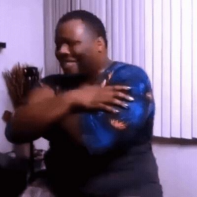 A Man In A Blue Shirt Is Dancing In Front Of A Window In A Room . GIF