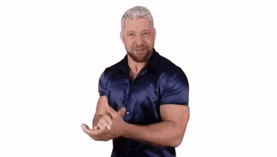 A Man In A Blue Shirt Is Dancing With His Hands Outstretched . GIF