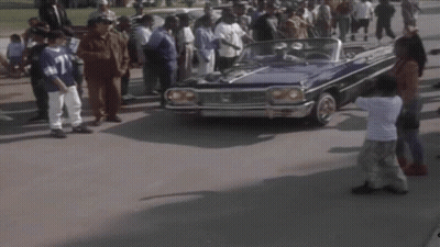 A Man In A Blue Shirt Is Driving A Blue Car GIF