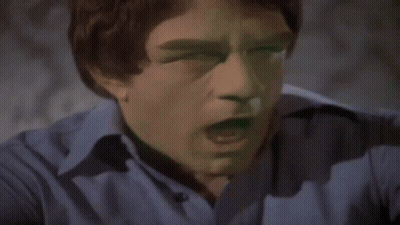 A Man In A Blue Shirt Is Flexing His Arm Muscles GIF