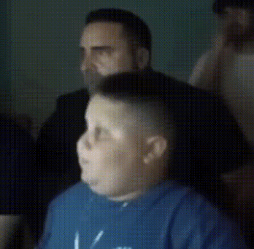 A Man In A Blue Shirt Is Getting His Hair Shaved By Another Man GIF