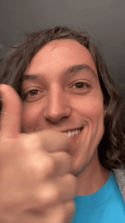 A Man In A Blue Shirt Is Giving A Thumbs Up GIF