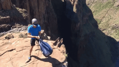 A Man In A Blue Shirt Is Holding A Bag That Says Alpina GIF