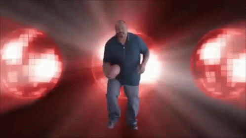 A Man In A Blue Shirt Is Holding A Basketball In Front Of A Red Background GIF