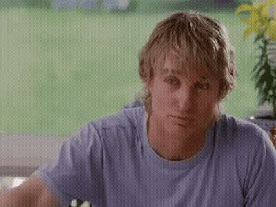 A Man In A Blue Shirt Is Holding A Bottle Of Coke Over His Head . GIF