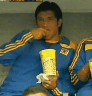 a man in a blue shirt is holding a cup of coca cola