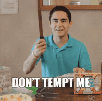 A Man In A Blue Shirt Is Holding A Knife In Front Of A Box That Says Deeps GIF