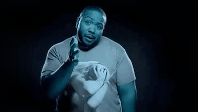 A Man In A Blue Shirt Is Holding A Pair Of Scissors In His Hands . GIF
