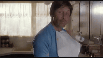 A Man In A Blue Shirt Is Holding A Piece Of Paper In His Mouth . GIF