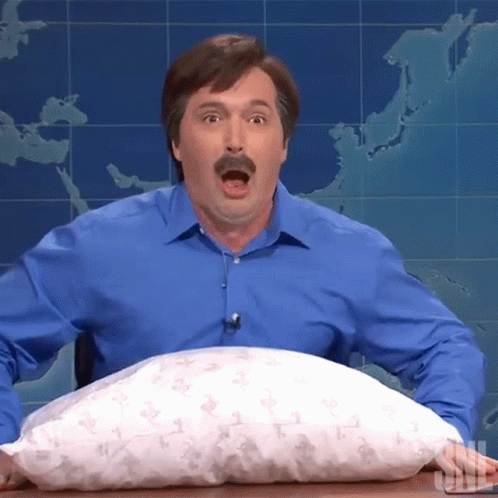 A Man In A Blue Shirt Is Holding A Pillow That Says Snl GIF