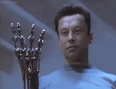 A Man In A Blue Shirt Is Holding A Robotic Arm In His Hand . GIF