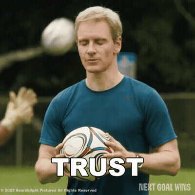 A Man In A Blue Shirt Is Holding A Soccer Ball And The Word Trust Is Above Him GIF