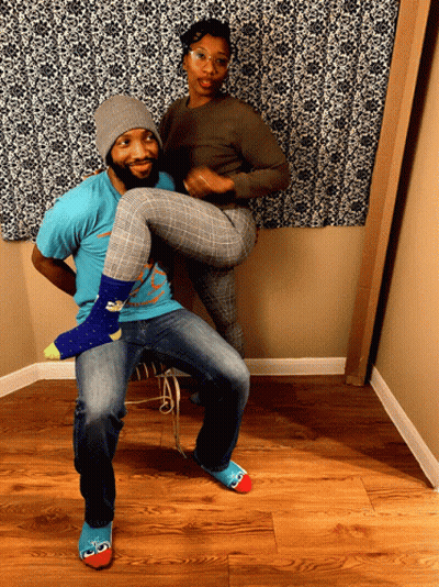 A Man In A Blue Shirt Is Holding A Woman 'S Legs GIF