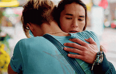 A Man In A Blue Shirt Is Hugging A Woman In A Blue Shirt GIF