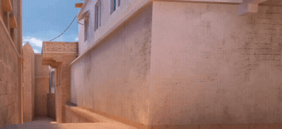 A Man In A Blue Shirt Is Jumping In The Air In Front Of A Building With A Sign That Says ' Ambulance ' GIF