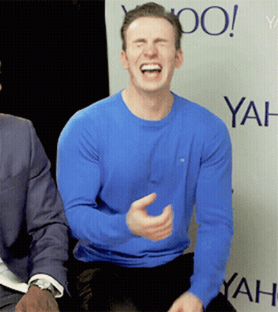 A Man In A Blue Shirt Is Laughing In Front Of A Yahoo Banner GIF