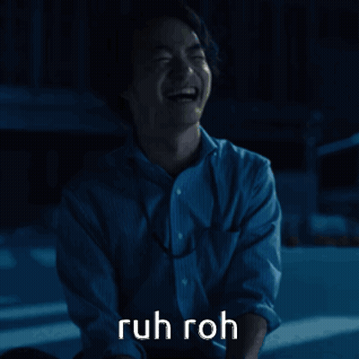 A Man In A Blue Shirt Is Laughing With The Words Ruh Roh Written Above Him GIF