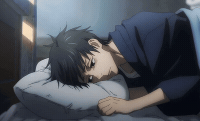 A Man In A Blue Shirt Is Laying On A Bed With His Head On A White Pillow GIF