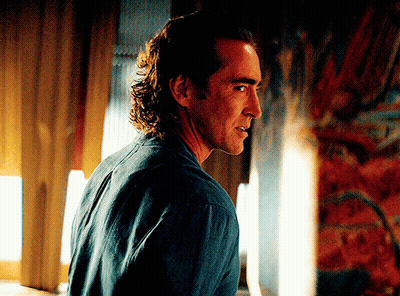 A Man In A Blue Shirt Is Looking At Something GIF