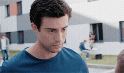 A Man In A Blue Shirt Is Looking At Something GIF