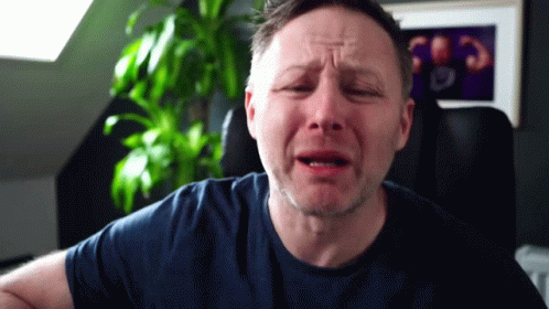 A Man In A Blue Shirt Is Making A Funny Face GIF