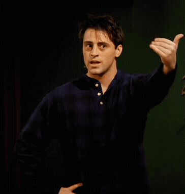 A Man In A Blue Shirt Is Making A Funny Face And Pointing At Something GIF