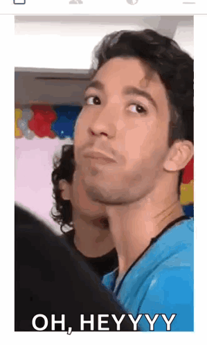 A Man In A Blue Shirt Is Making A Funny Face And Says Oh , Heyyyy GIF