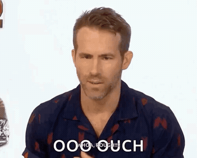 A Man In A Blue Shirt Is Making A Funny Face While Talking To Someone . GIF