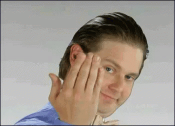 A Man In A Blue Shirt Is Making A Funny Face With His Hands . GIF