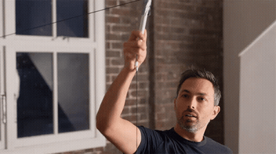 A Man In A Blue Shirt Is Measuring Something GIF
