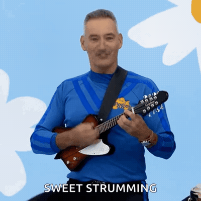 A Man In A Blue Shirt Is Playing A Guitar And Says Sweet Strumming In The Corner GIF