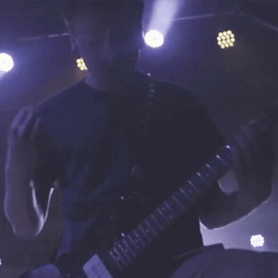 A Man In A Blue Shirt Is Playing A Guitar With The Letters H And I On The Neck GIF
