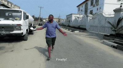 A Man In A Blue Shirt Is Running Down A Street With The Words Finally Written Below Him GIF