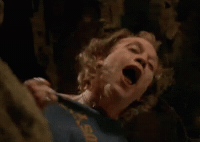 A Man In A Blue Shirt Is Screaming In A Dark Room . GIF