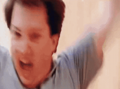 A Man In A Blue Shirt Is Screaming With His Arms Outstretched . GIF