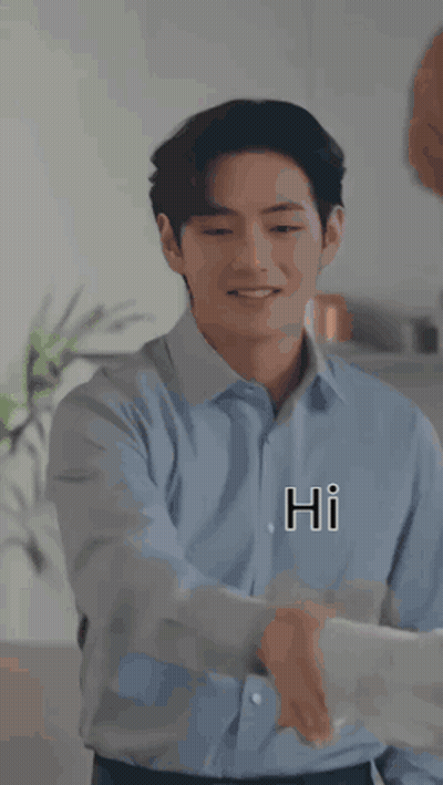 A Man In A Blue Shirt Is Shaking Hands With Another Man In A Kitchen While Smiling . GIF