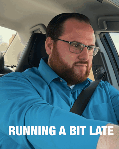 A Man In A Blue Shirt Is Sitting In A Car With The Words Running A Bit Late Behind Him GIF