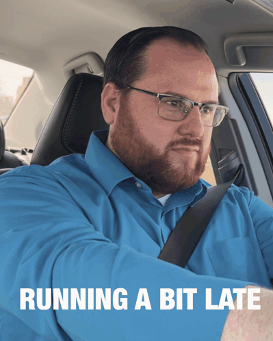 A Man In A Blue Shirt Is Sitting In A Car With The Words Running A Bit Late Behind Him GIF