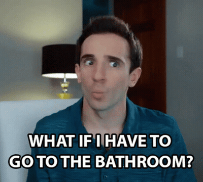 A Man In A Blue Shirt Is Sitting In A Chair And Saying What If I Have To Go To The Bathroom ? GIF