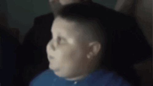 A Man In A Blue Shirt Is Sitting In A Chair With His Eyes Closed . GIF