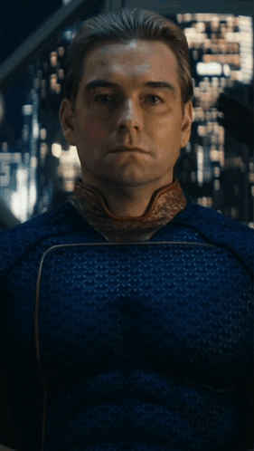 A Man In A Blue Shirt Is Sitting In Front Of A Painting With His Eyes Closed GIF