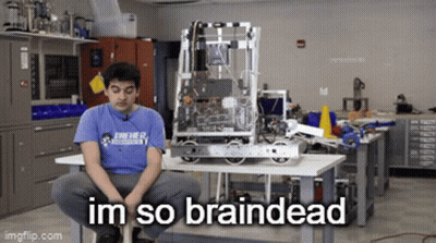 A Man In A Blue Shirt Is Sitting In Front Of A Robot That Says Im So Braindead On It GIF