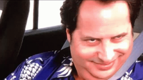 A Man In A Blue Shirt Is Sitting In The Back Seat Of A Car . GIF