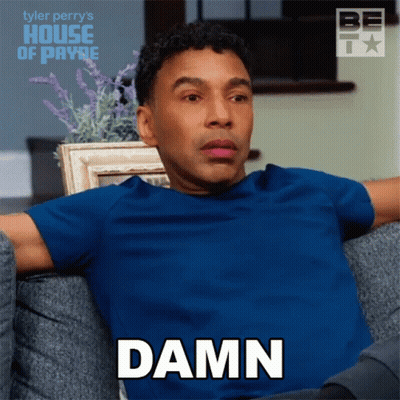 A Man In A Blue Shirt Is Sitting On A Couch And Saying " Damn " GIF