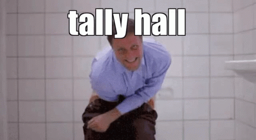 A Man In A Blue Shirt Is Sitting On A Toilet With The Words Tally Hall Above Him GIF